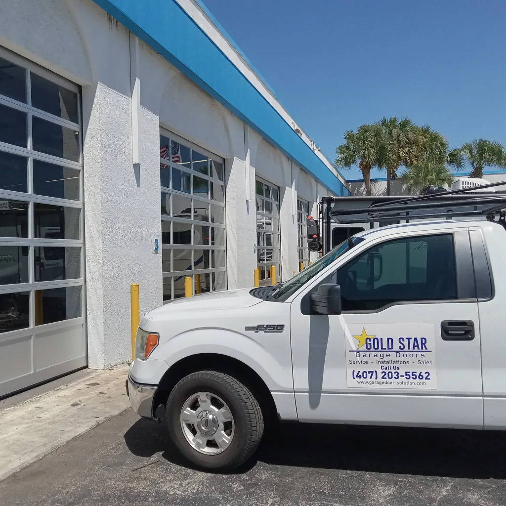 Gold Star Garage Doors service truck outside a row of commercial garage doors
