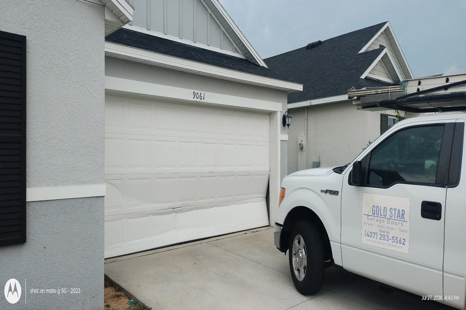 Gold Star Garage Doors service truck parked outside a newly serviced residential garage door in Davenport, FL
